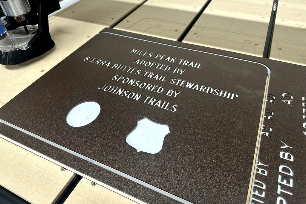 CNC router engraving a sponsor trail sign at Silver State Plastics in Sparks, NV