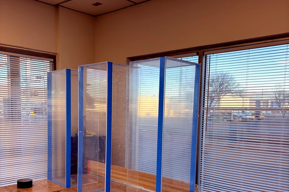 Tall clear acrylic display cases during assembly