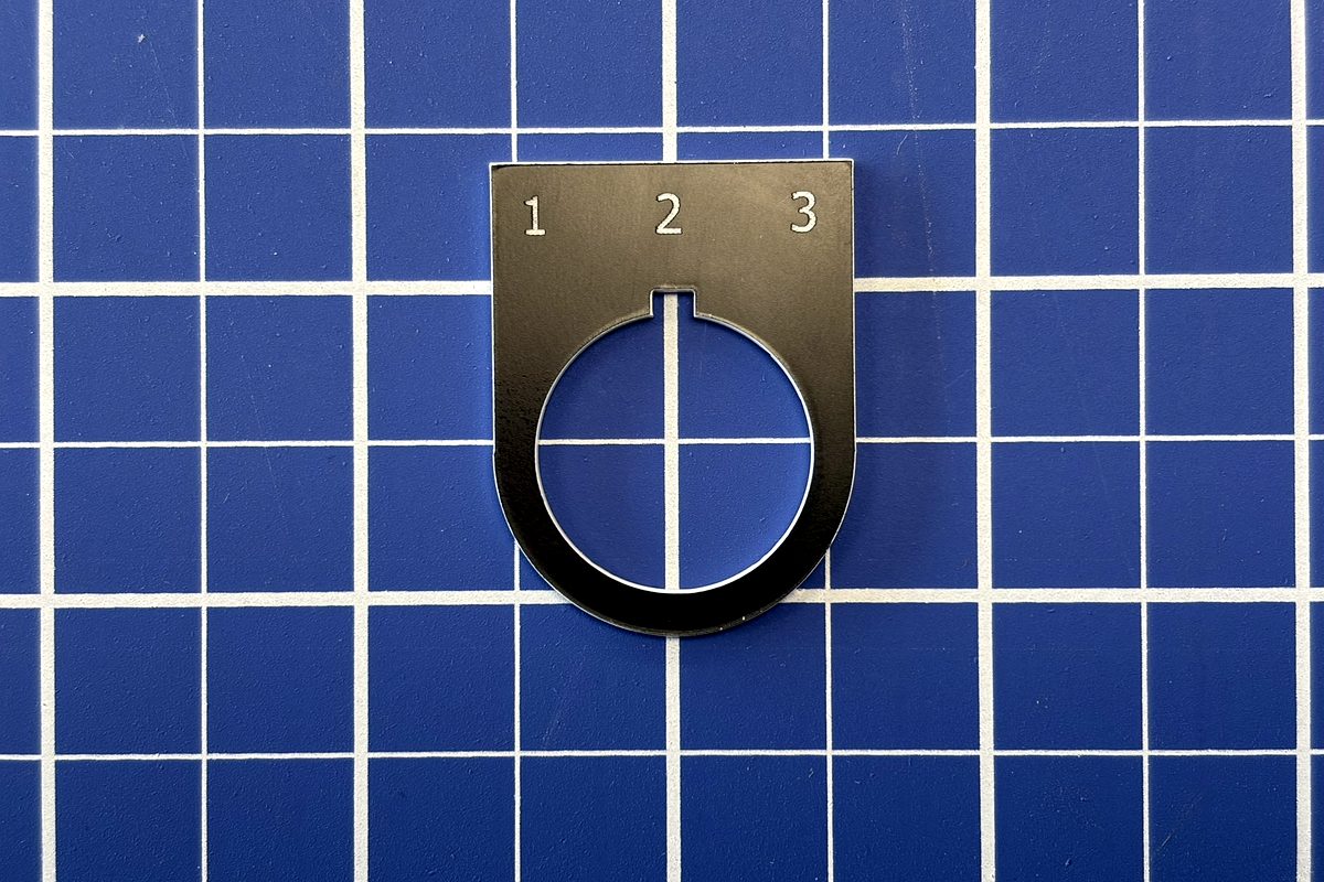 Laser-cut pushbutton legend plate with engraved position numbers