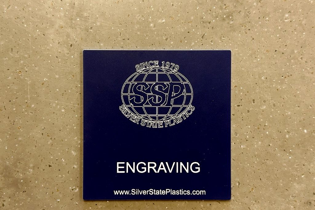 Silver State Plastics logo engraved on blue two-ply sample chip