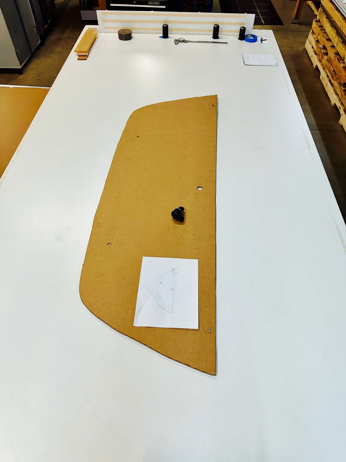 Cardboard template with paper diagram on workshop table.
